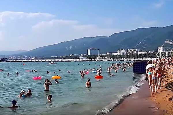 Море на пляже и много туристов